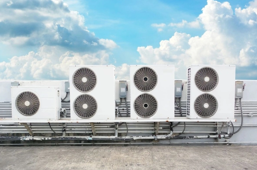 A row of air conditioners on top of a building.